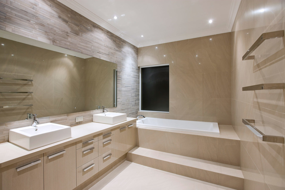 This is an example of a mid-sized contemporary master bathroom in Perth with flat-panel cabinets, light wood cabinets, an undermount tub, beige tile, beige walls, porcelain tile, porcelain floors, an integrated sink, granite benchtops and beige floor.