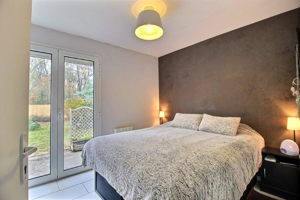 This is an example of a small contemporary master bedroom in Bordeaux with brown walls, ceramic floors and beige floor.
