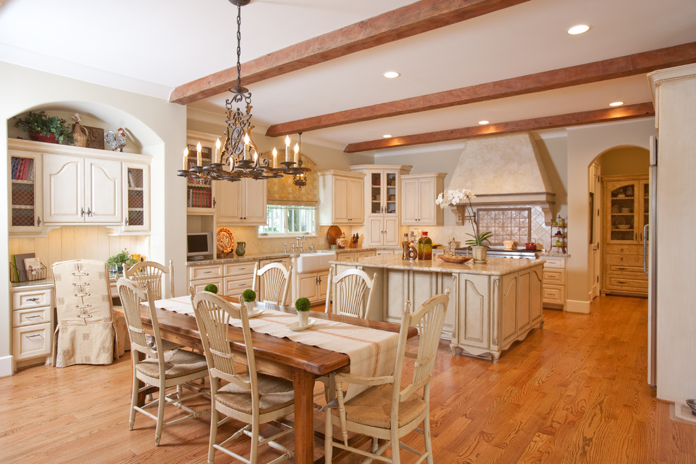 Inspiration for a large u-shaped eat-in kitchen in Houston with raised-panel cabinets, beige cabinets, a farmhouse sink, granite benchtops, beige splashback, ceramic splashback, stainless steel appliances, with island and medium hardwood floors.