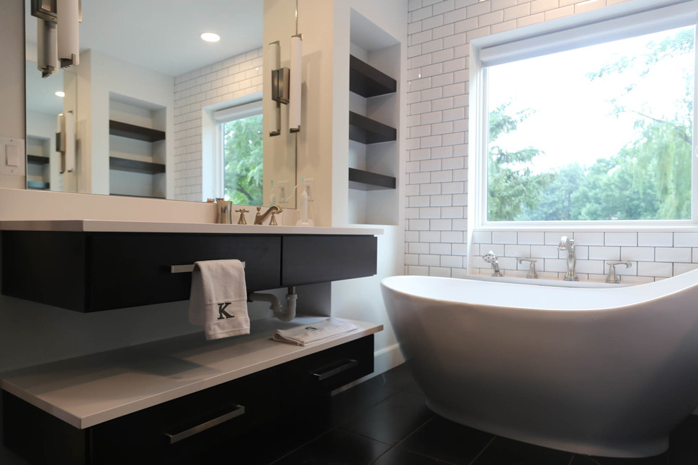 Example of a mid-sized transitional master white tile and subway tile porcelain tile and black floor freestanding bathtub design with flat-panel cabinets, dark wood cabinets, a two-piece toilet, white walls, an undermount sink, quartzite countertops, a hinged shower door and white countertops