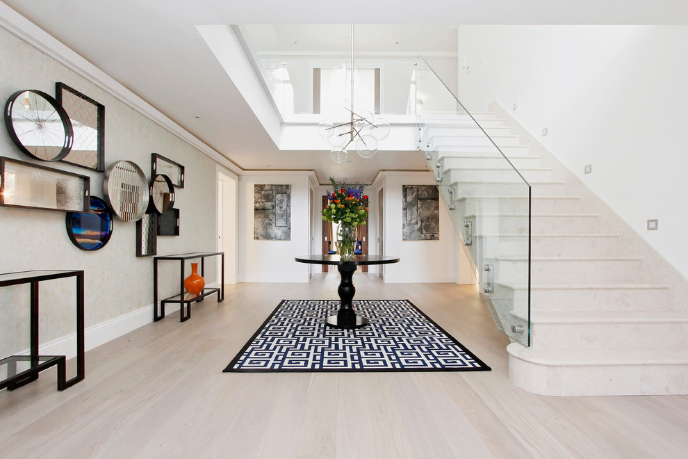 Design ideas for a large contemporary foyer in Berkshire with white walls, light hardwood floors and wallpaper.