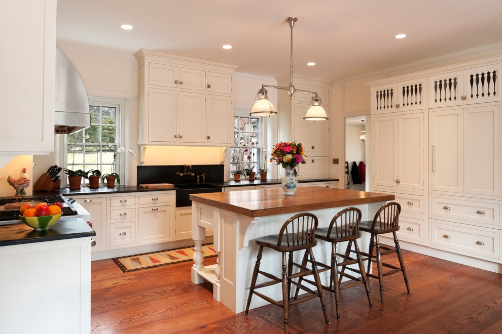 Design ideas for a traditional u-shaped kitchen in Philadelphia with recessed-panel cabinets, white cabinets and wood benchtops.