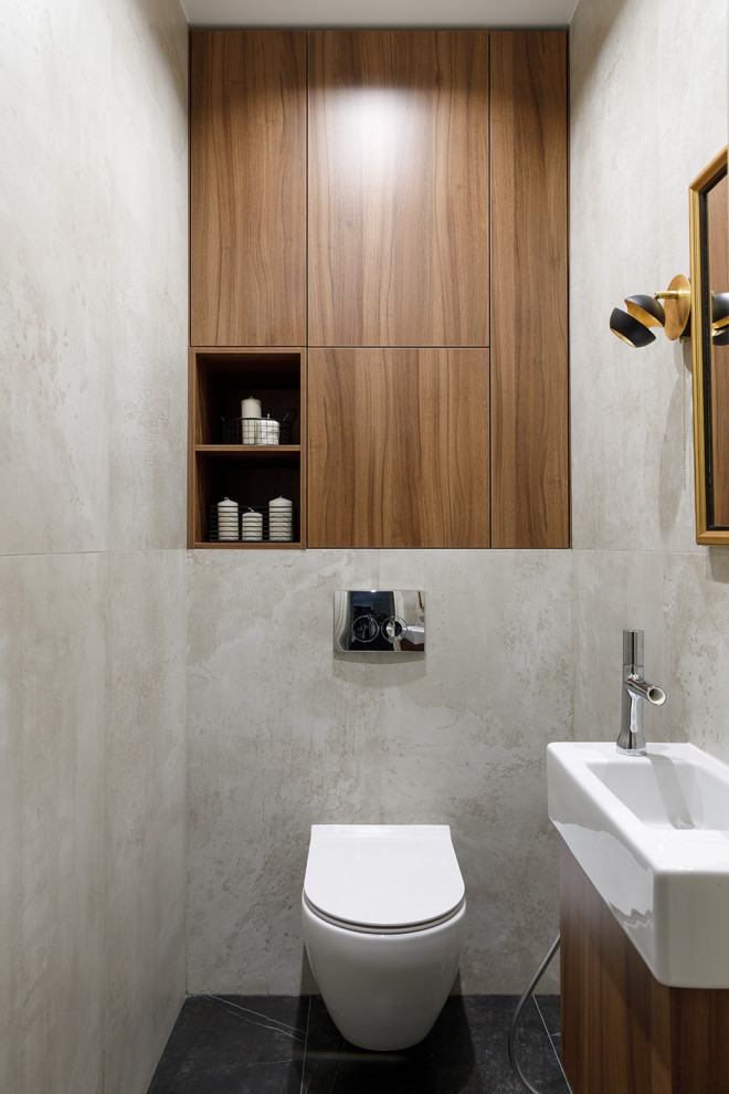 This is an example of a small contemporary powder room in Saint Petersburg with brown cabinets, a wall-mount toilet, beige tile, porcelain tile, beige walls, porcelain floors, an integrated sink, solid surface benchtops, black floor, white benchtops and a floating vanity.