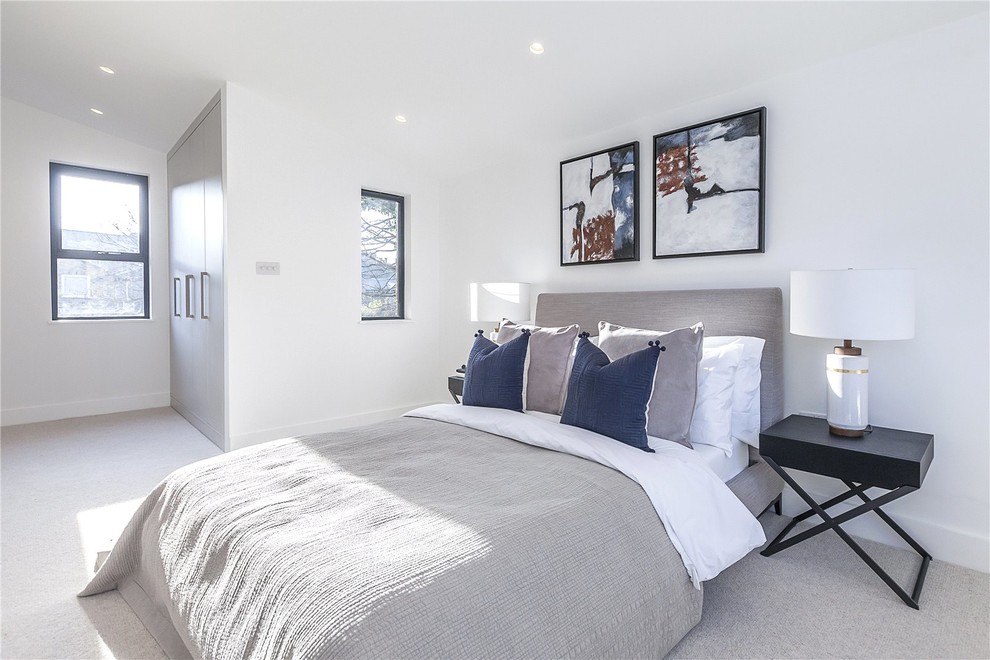 This is an example of a mid-sized transitional master bedroom in London with white walls, carpet and grey floor.