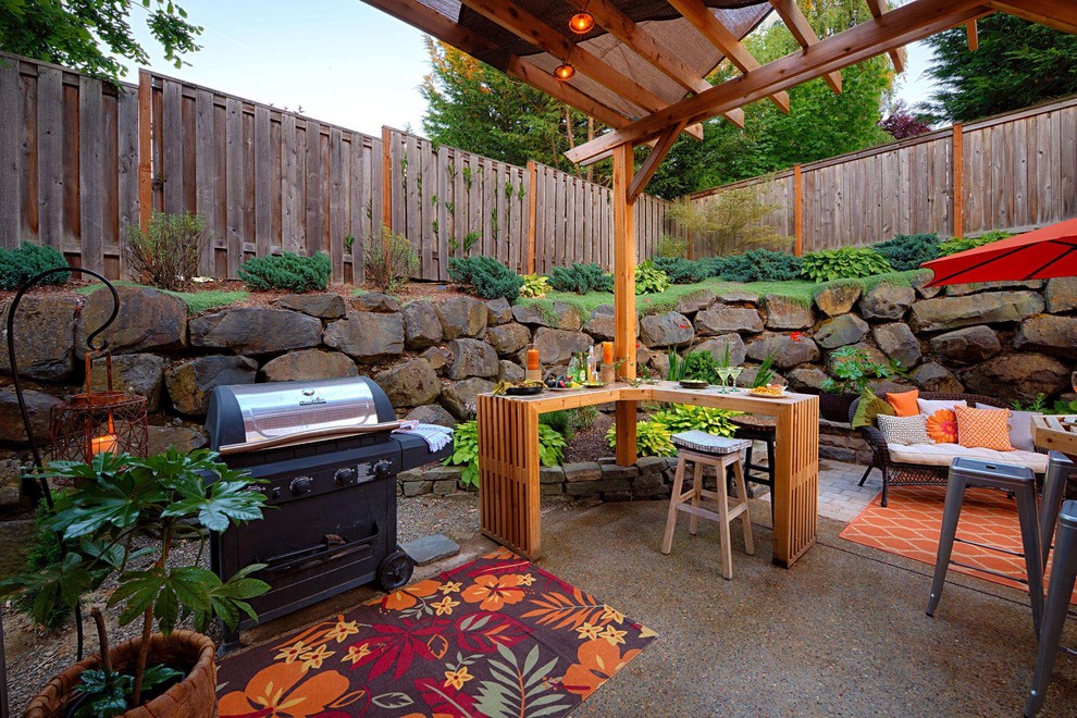 Inspiration for a large contemporary backyard patio in Portland with natural stone pavers, a pergola and an outdoor kitchen.