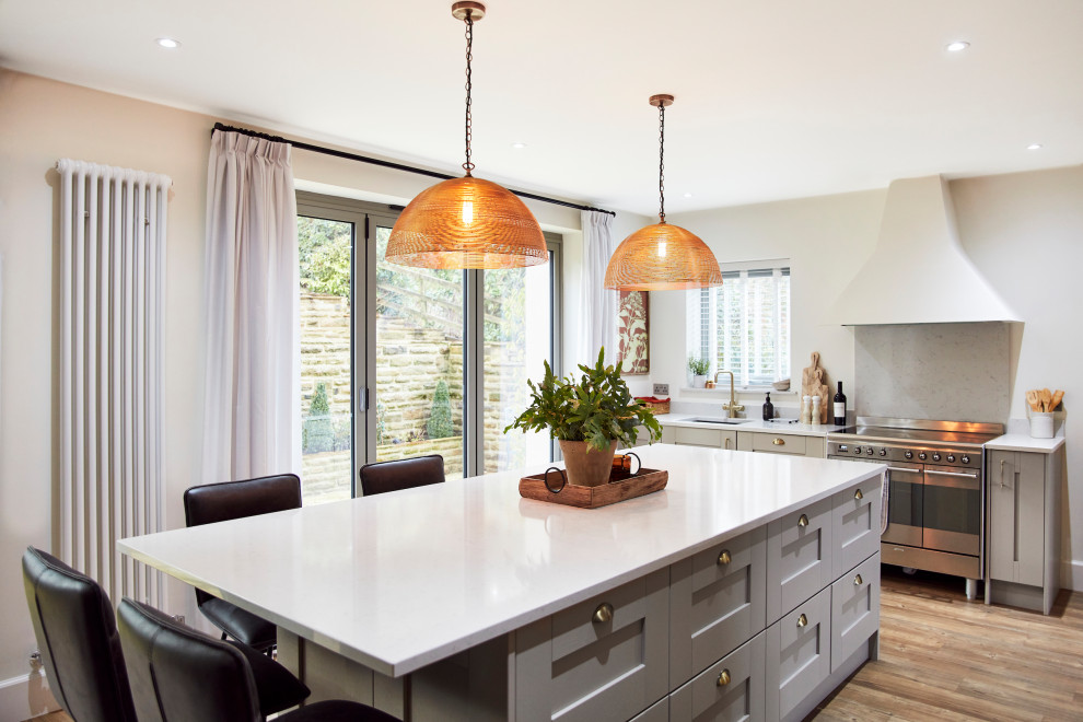 Inspiration for a mid-sized transitional open plan kitchen in Other with an integrated sink, shaker cabinets, beige cabinets, quartzite benchtops, white splashback, stone slab splashback, stainless steel appliances, vinyl floors, with island, beige floor and white benchtop.