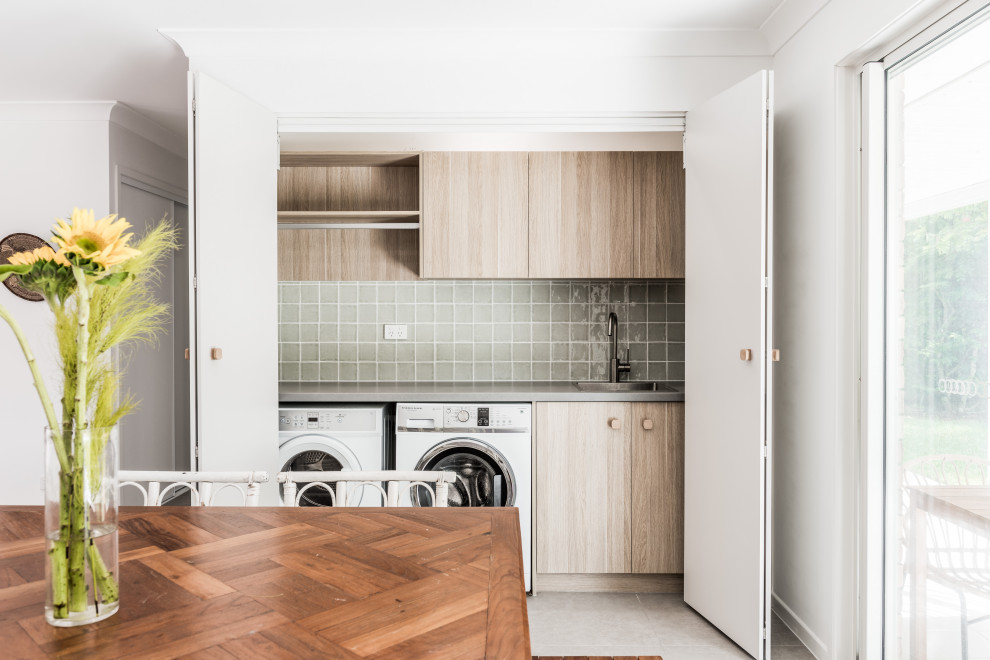 Design ideas for a contemporary laundry room in Gold Coast - Tweed with green splashback, cement tile splashback, a side-by-side washer and dryer and grey benchtop.