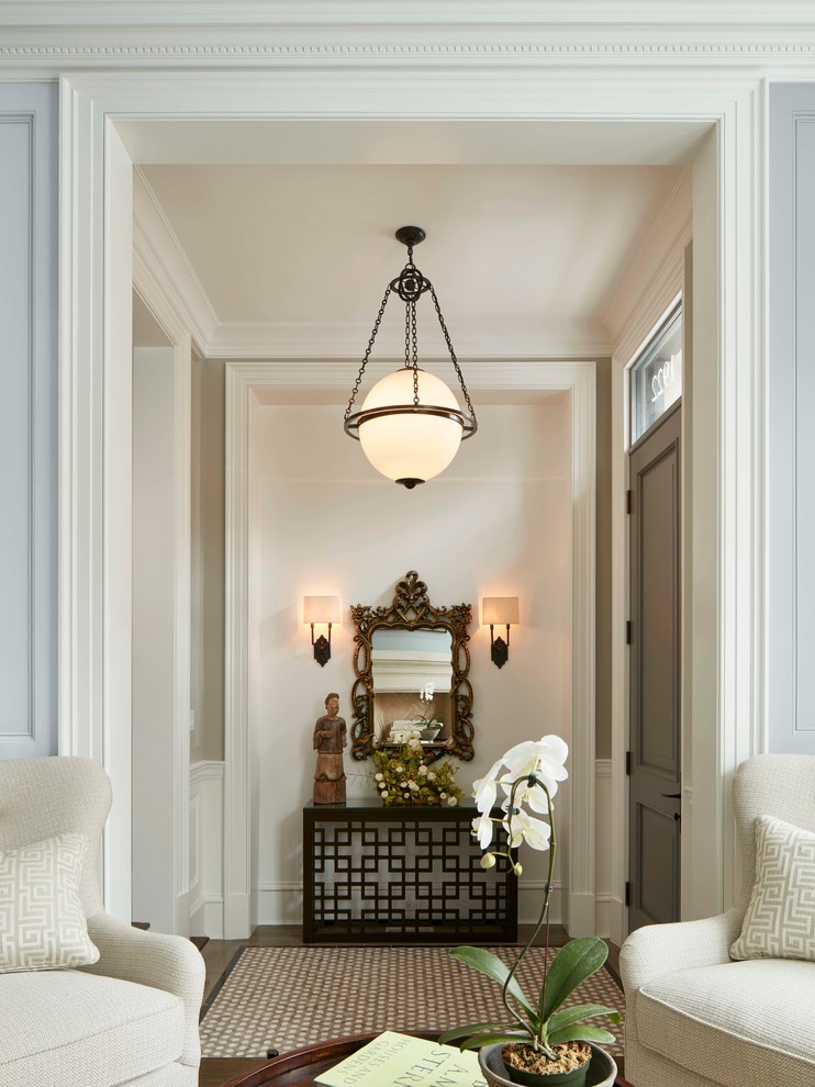 This is an example of a traditional entryway in Chicago with white walls, a single front door and a gray front door.