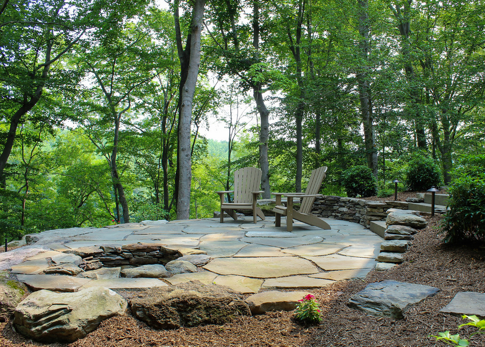 Design ideas for a mid-sized transitional sloped shaded garden for summer in DC Metro with a fire feature and natural stone pavers.