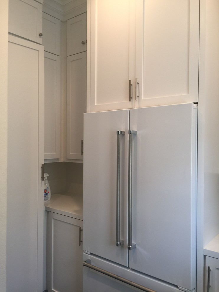 Kitchen pantry - large transitional u-shaped dark wood floor kitchen pantry idea in Orange County with recessed-panel cabinets, white cabinets and solid surface countertops