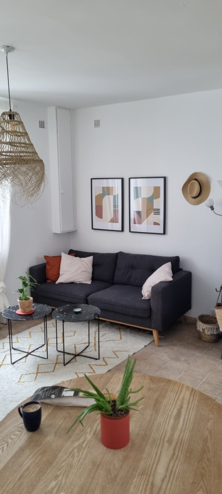 Photo of a mid-sized beach style open concept living room in Nantes with white walls, terra-cotta floors, no fireplace and pink floor.