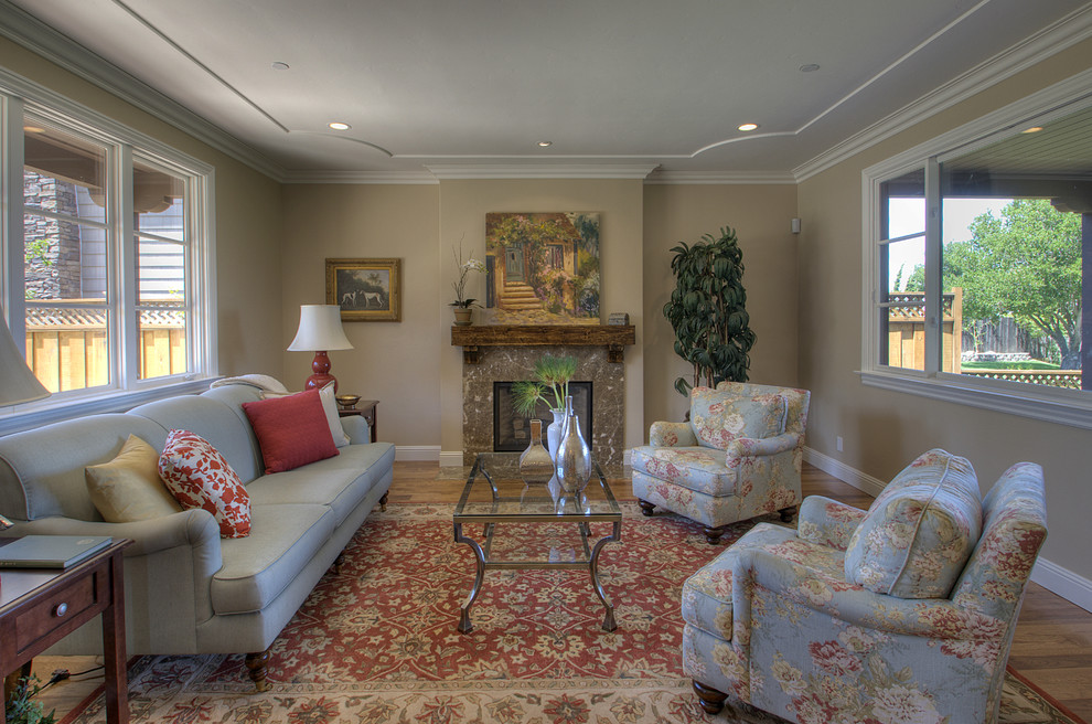This is an example of a large traditional living room in San Francisco with beige walls and a standard fireplace.