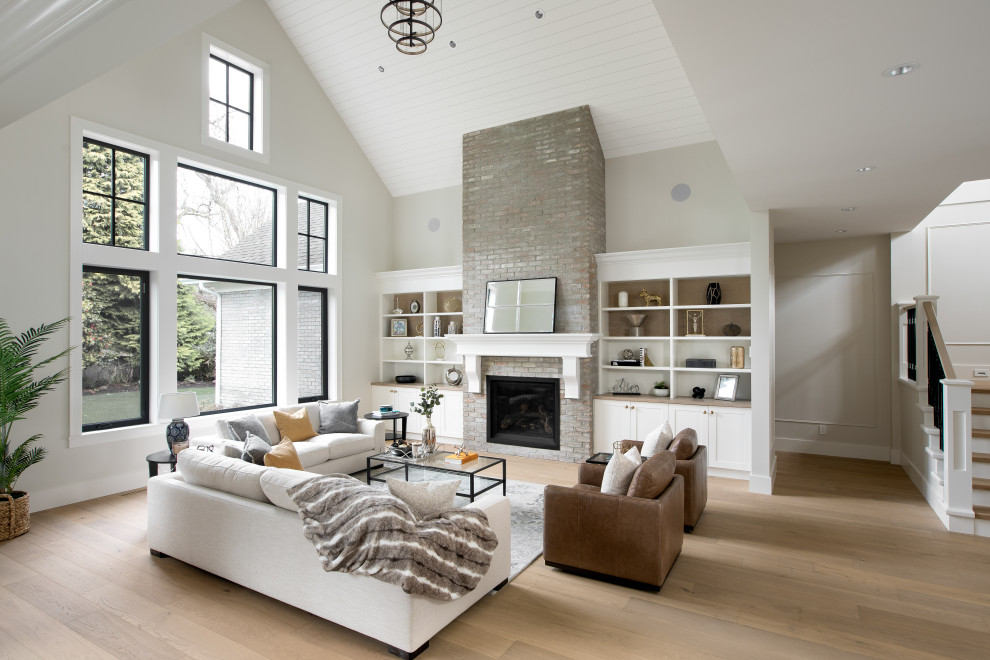 Photo of a transitional formal open concept living room in Vancouver with white walls, light hardwood floors, a brick fireplace surround, a standard fireplace, no tv, brown floor, timber and panelled walls.