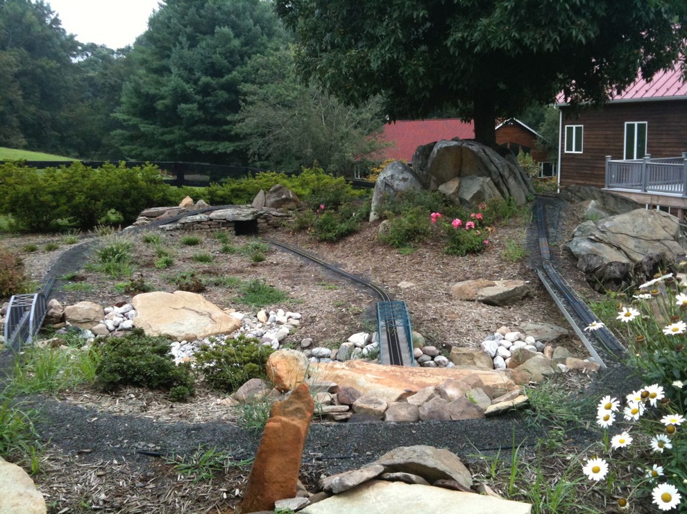 Design ideas for a large rustic partial sun backyard stone formal garden for summer.