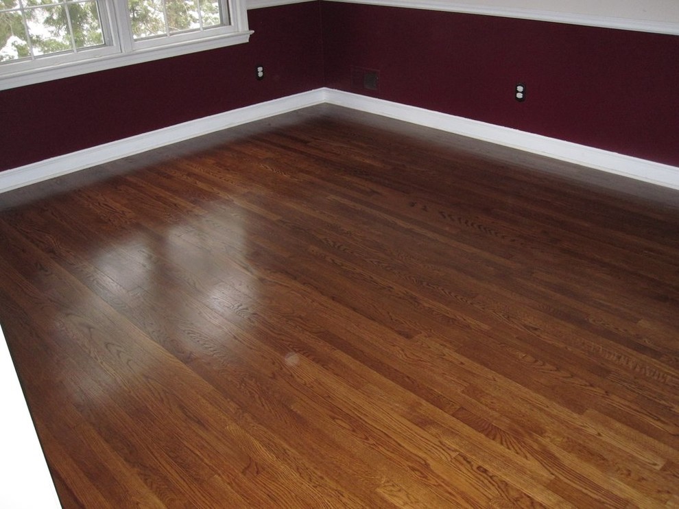 Mid-sized transitional guest medium tone wood floor bedroom photo with red walls