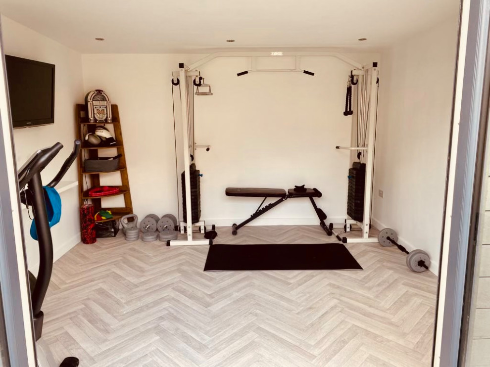 Large contemporary multipurpose gym in West Midlands with white walls, vinyl floors, grey floor and wood.