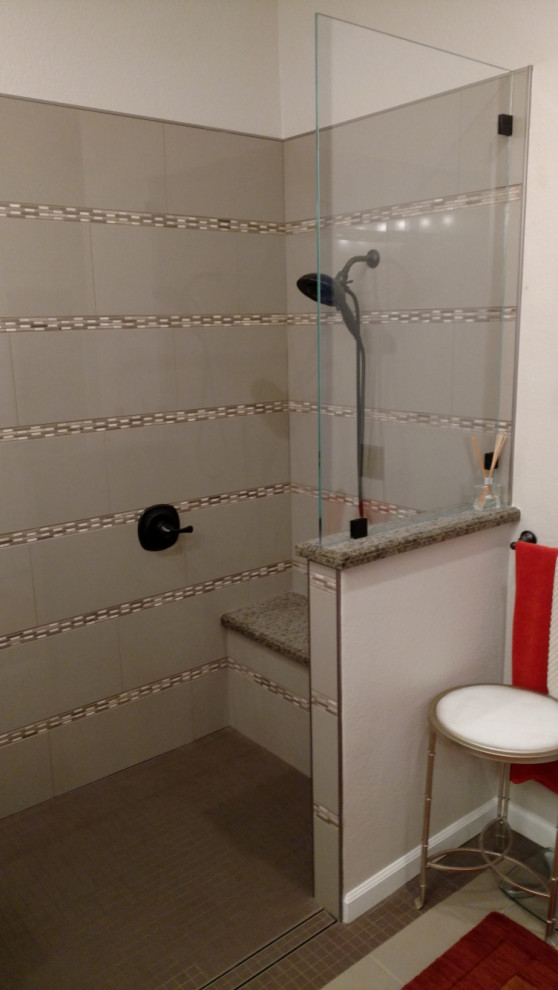 Inredning av ett modernt stort grå grått en-suite badrum, med luckor med upphöjd panel, vita skåp, granitbänkskiva, en öppen dusch, en toalettstol med separat cisternkåpa, grå kakel, keramikplattor, vita väggar, klinkergolv i keramik, ett undermonterad handfat, med dusch som är öppen och brunt golv