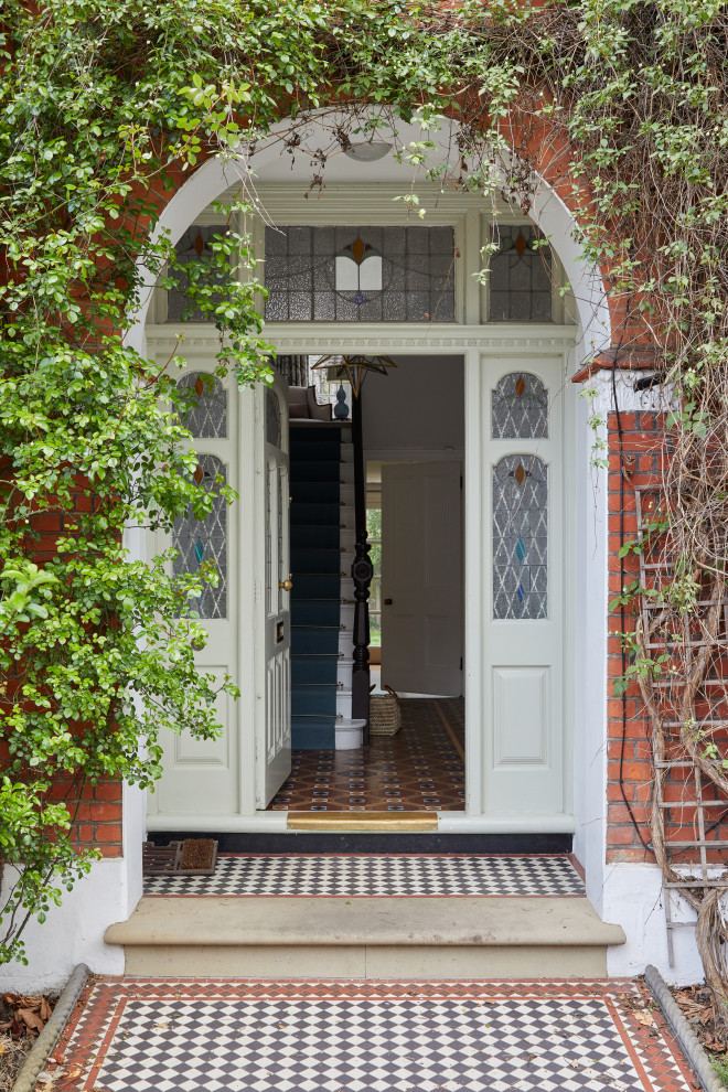 Esempio di un ingresso o corridoio con una porta singola, una porta verde e pavimento multicolore