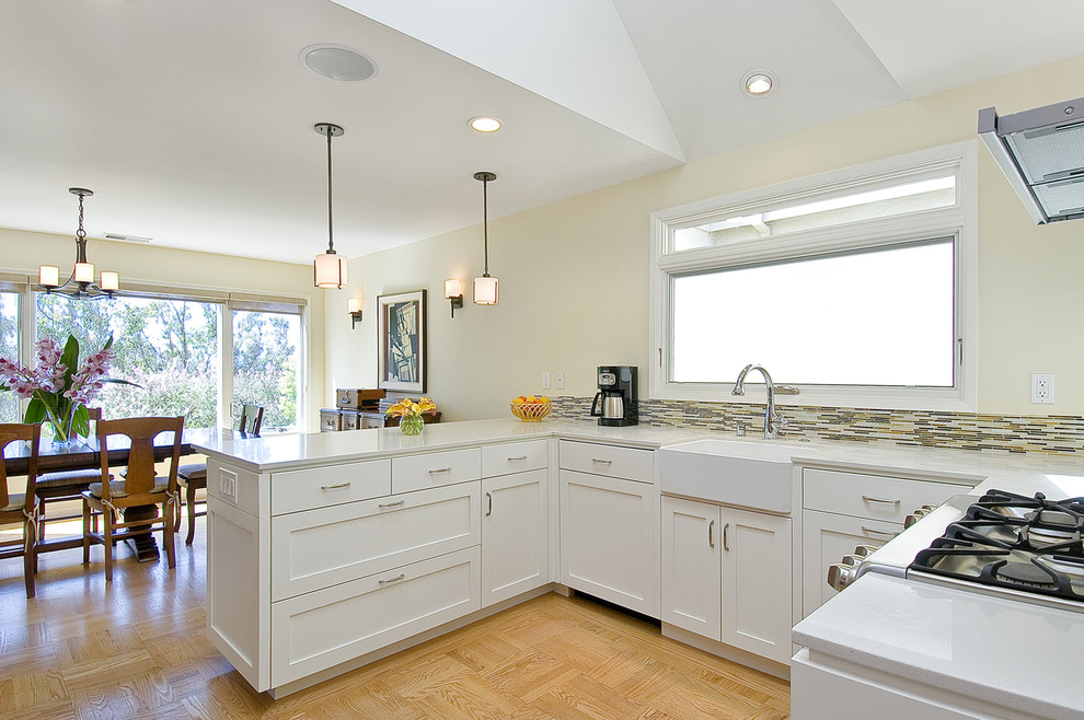Photo of a contemporary kitchen in San Francisco with a farmhouse sink, shaker cabinets, white cabinets and matchstick tile splashback.