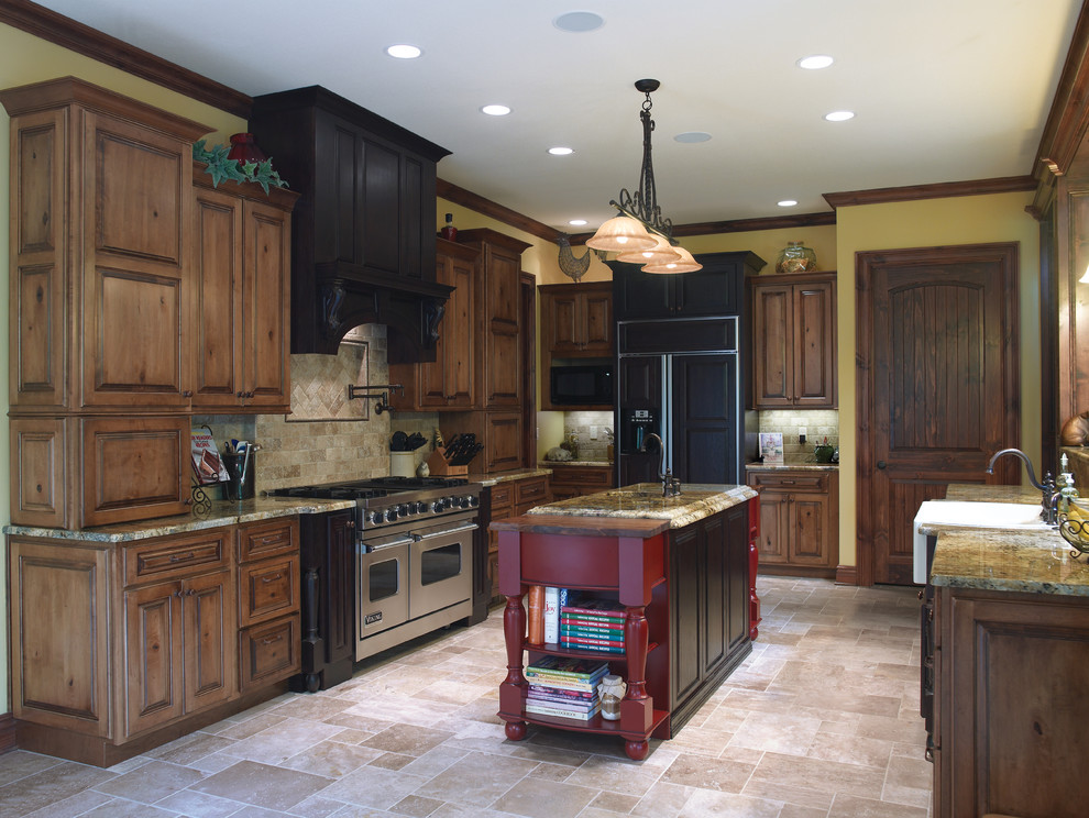 Inspiration for a large country u-shaped separate kitchen in Cincinnati with medium wood cabinets, with island, an undermount sink, raised-panel cabinets, granite benchtops, beige splashback, travertine splashback, stainless steel appliances, travertine floors and beige floor.