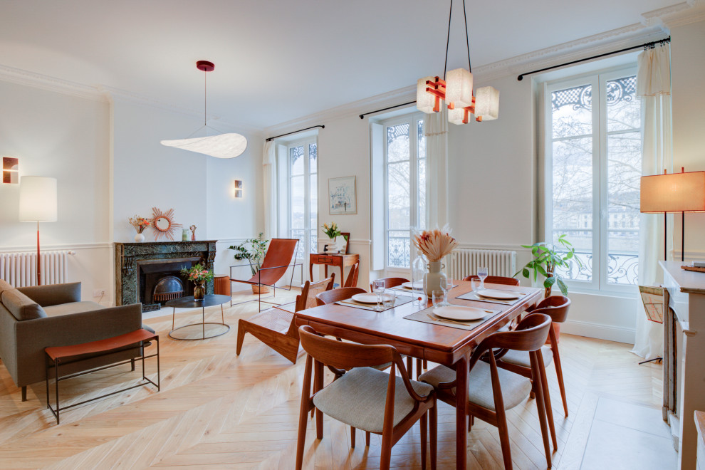 Design ideas for a mid-sized scandinavian dining room in Lyon with a standard fireplace, a wood fireplace surround and brown floor.