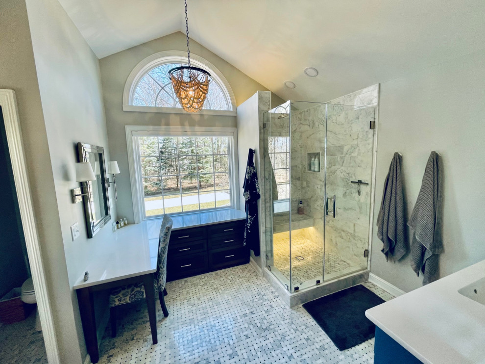 На фото: главная ванная комната среднего размера в стиле неоклассика (современная классика) с фасадами в стиле шейкер, синими фасадами, угловым душем, унитазом-моноблоком, белой плиткой, мраморной плиткой, серыми стенами, мраморным полом, врезной раковиной, столешницей из искусственного кварца, белым полом, душем с распашными дверями, белой столешницей, нишей, тумбой под две раковины и встроенной тумбой с
