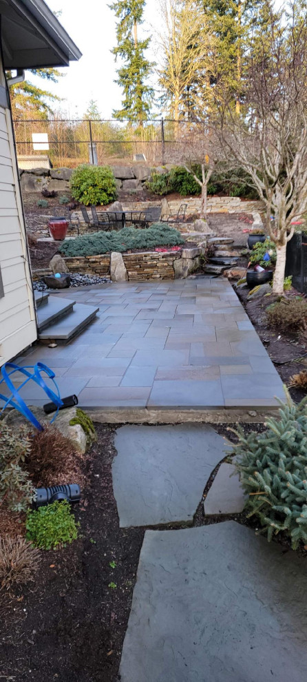 This is an example of a modern back garden in Seattle with a pathway and natural stone paving.