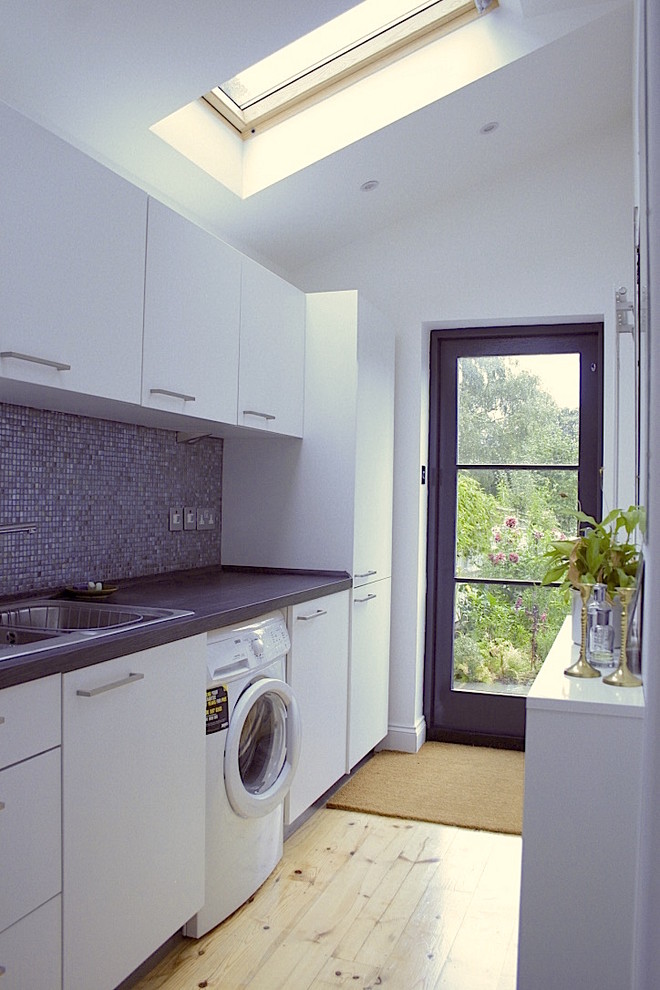 Photo of an eclectic laundry room in Surrey.