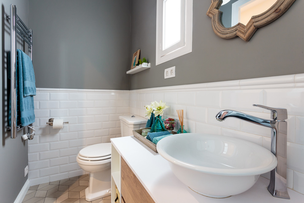 Photo of a small transitional powder room in Barcelona with a two-piece toilet, white tile, beige tile, subway tile, grey walls and a vessel sink.
