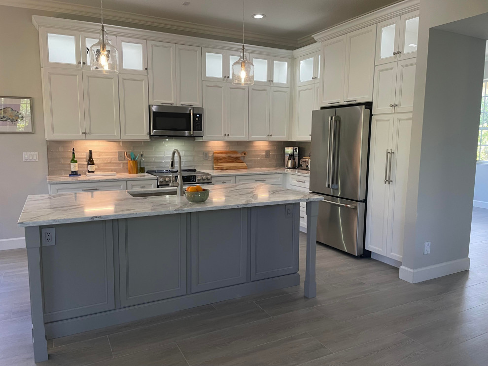 Inspiration for a transitional vinyl floor and gray floor eat-in kitchen remodel in Miami with a single-bowl sink, shaker cabinets, white cabinets, quartz countertops, gray backsplash, subway tile backsplash, stainless steel appliances, an island and gray countertops