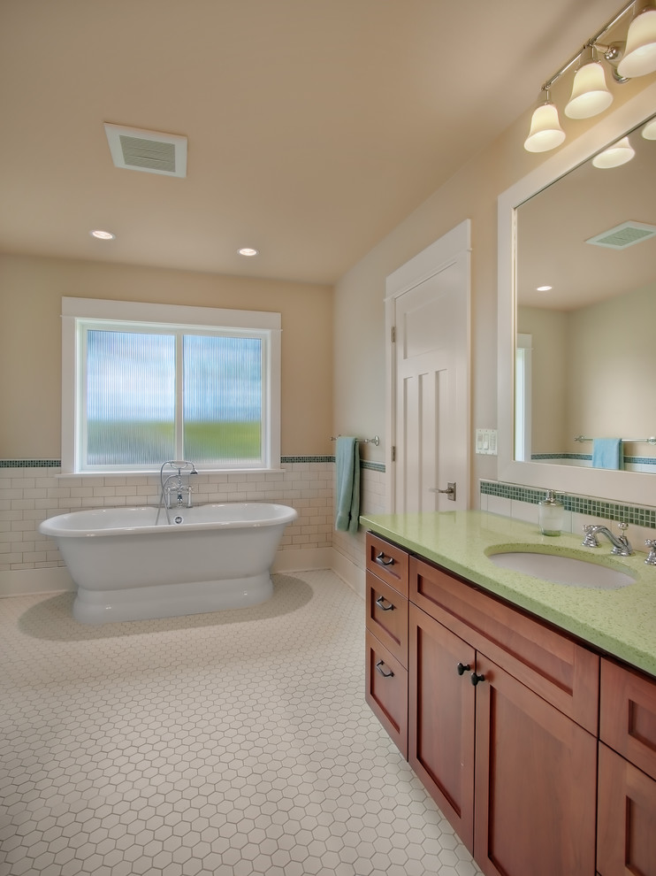 This is an example of a traditional bathroom in Seattle with a freestanding tub and green benchtops.