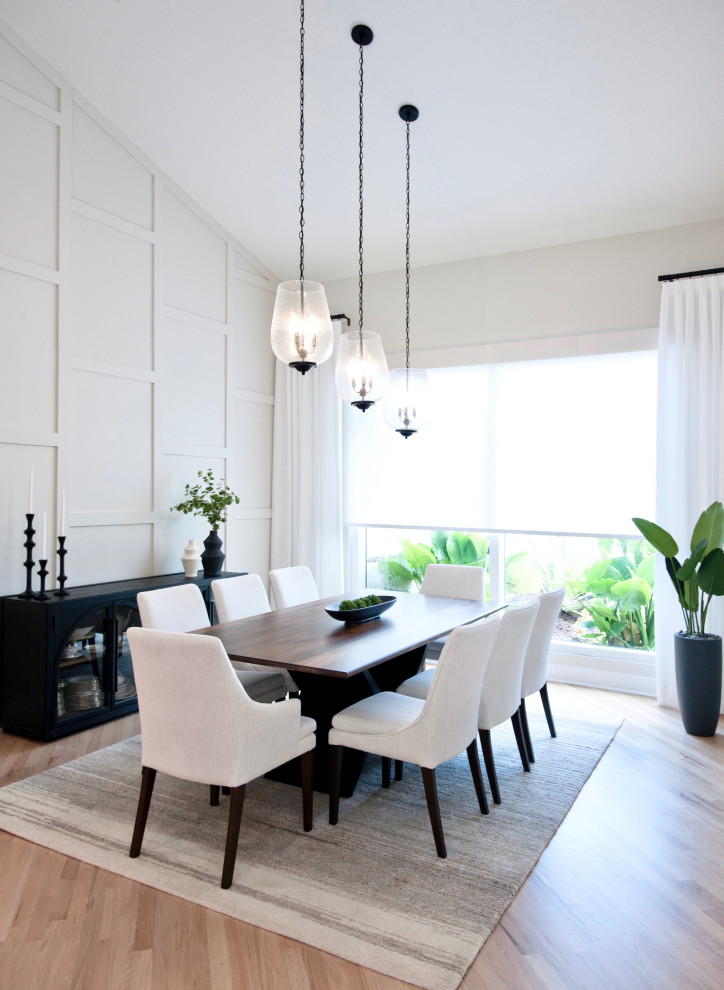 This is an example of a mid-sized transitional open plan dining in Miami with grey walls, light hardwood floors, beige floor, vaulted and wood walls.