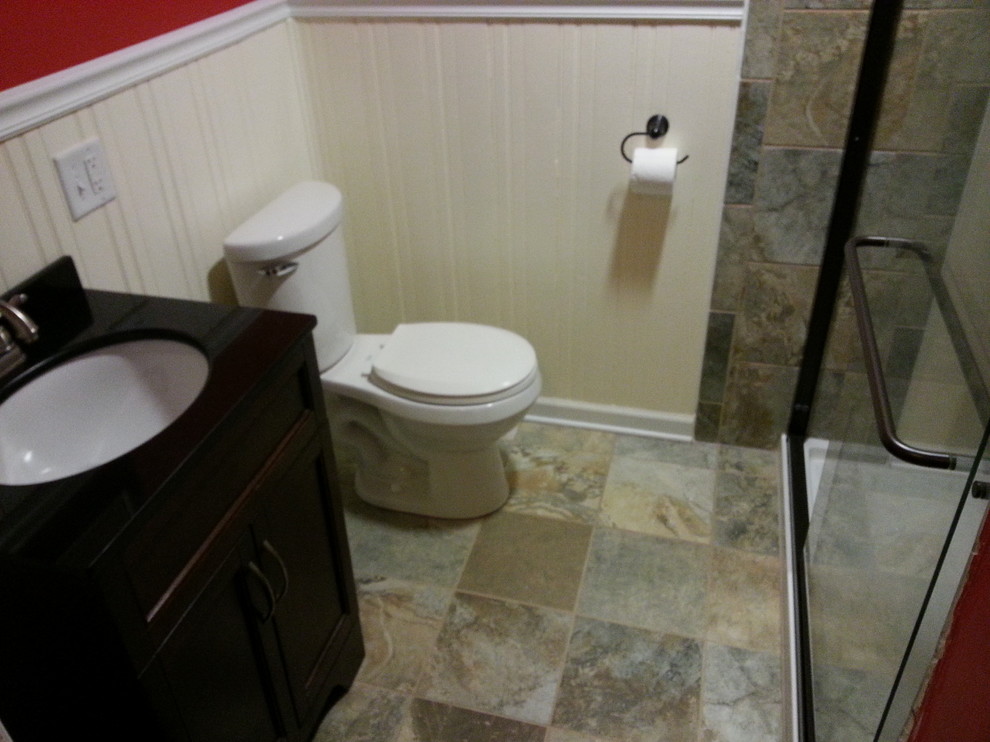 Example of a small arts and crafts 3/4 multicolored tile and stone tile slate floor alcove shower design in Grand Rapids with shaker cabinets, dark wood cabinets, a two-piece toilet, red walls, an undermount sink and granite countertops