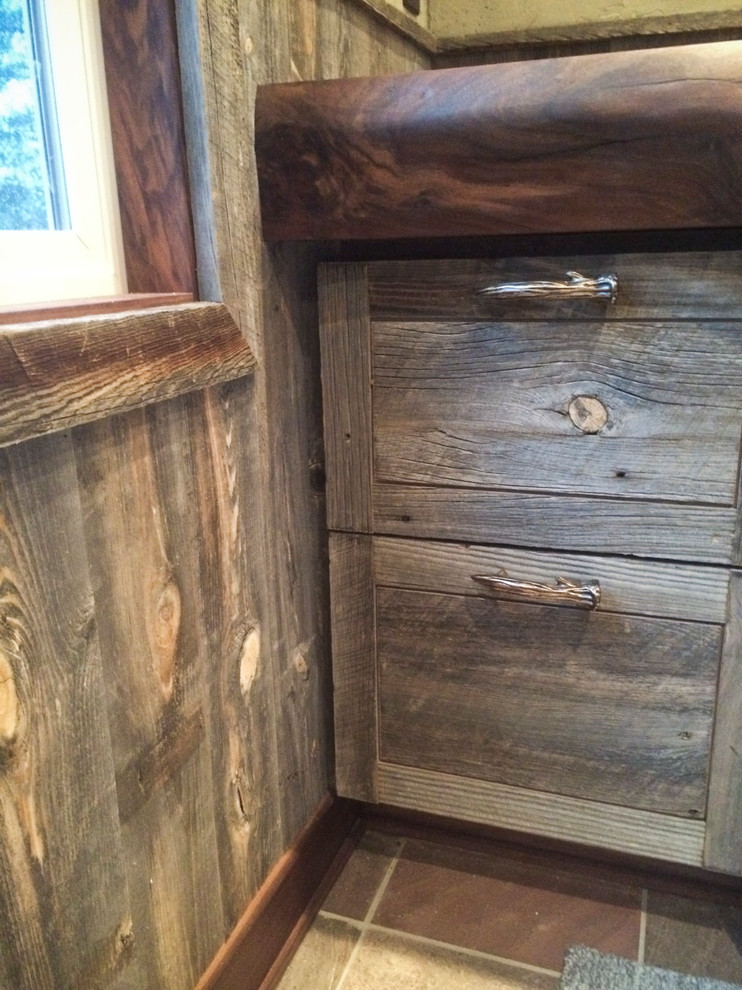Example of a small mountain style 3/4 brown tile slate floor bathroom design with distressed cabinets, wood countertops and beige walls