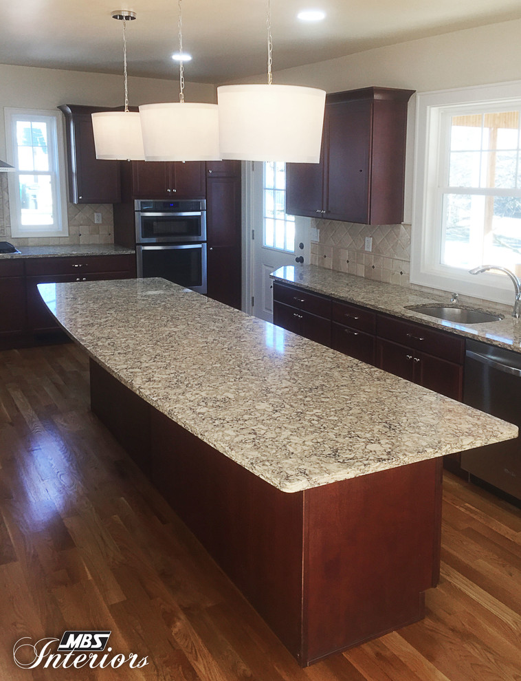Large transitional medium tone wood floor eat-in kitchen photo in Cincinnati with an undermount sink, recessed-panel cabinets, dark wood cabinets, quartz countertops, beige backsplash, stone tile backsplash, stainless steel appliances and an island