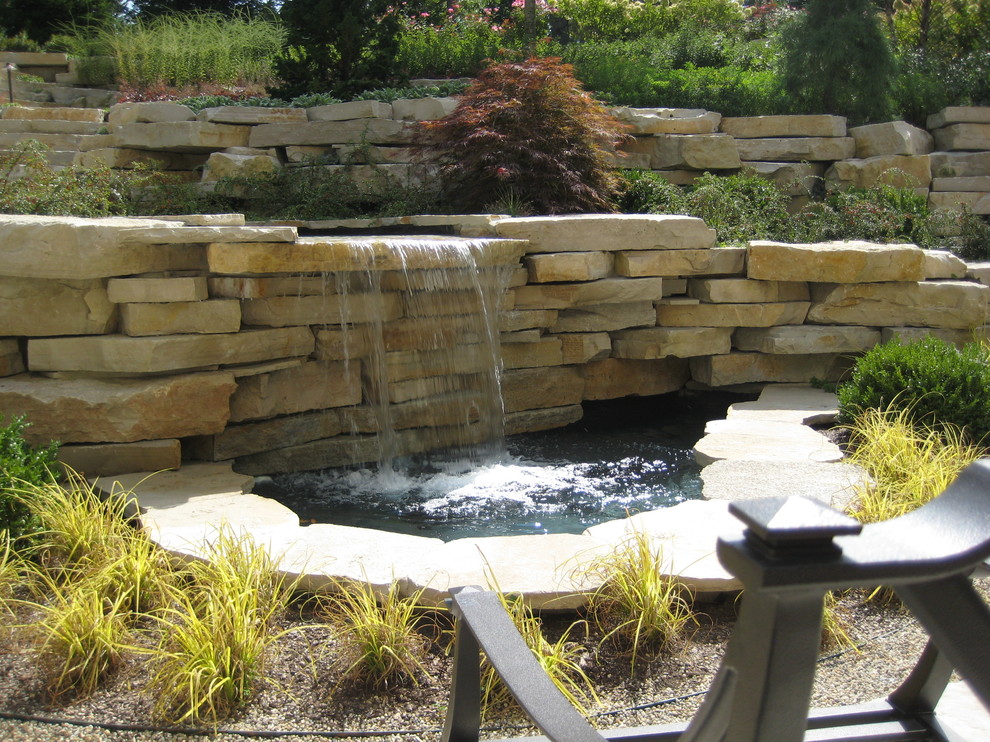 Photo of a mid-sized transitional backyard stone water fountain landscape in Chicago.