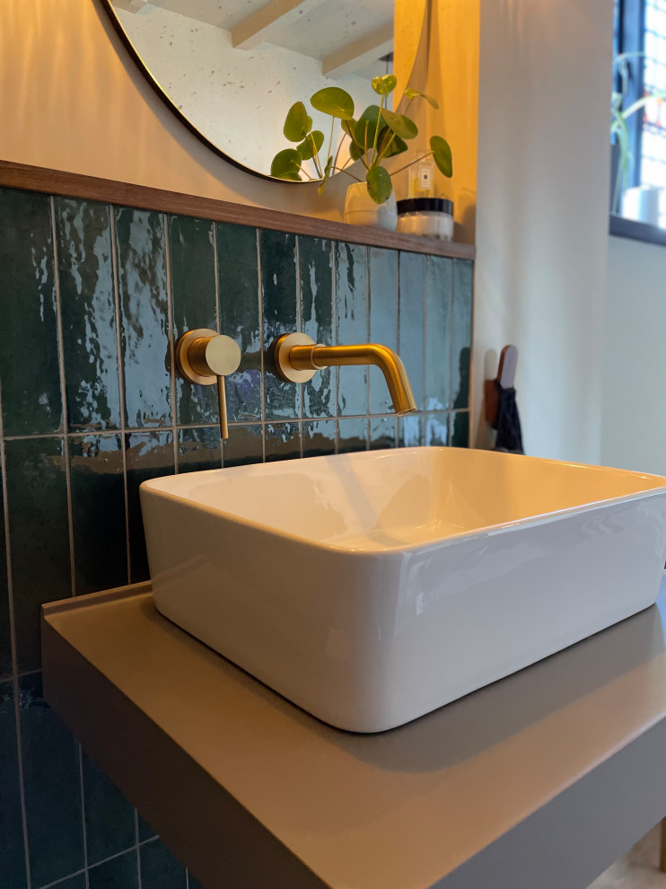 Mid-sized trendy kids' green tile and porcelain tile vinyl floor, brown floor, single-sink and exposed beam bathroom photo in Hertfordshire with gray cabinets, beige walls, a wall-mount sink, solid surface countertops, gray countertops and a floating vanity