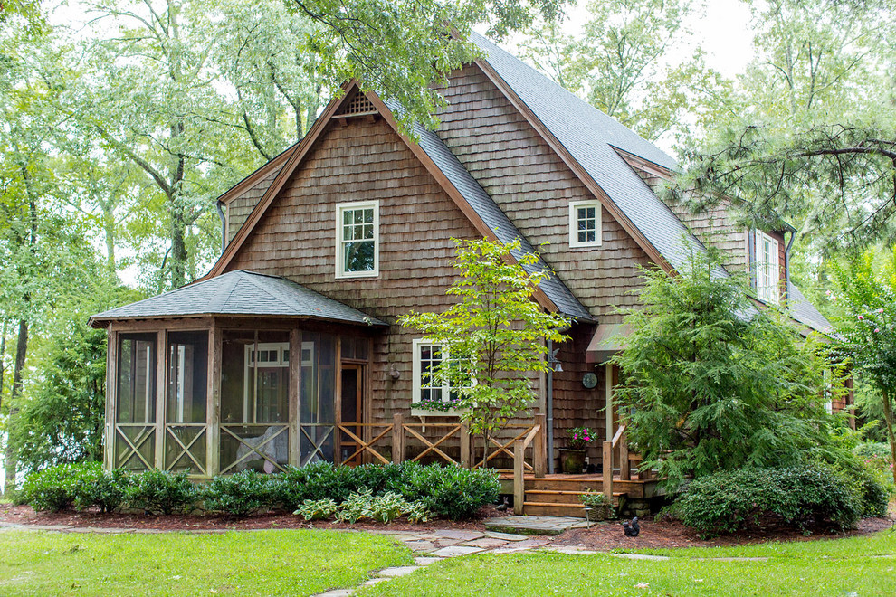 Design ideas for a country two-storey brown exterior in Other with wood siding and a gable roof.