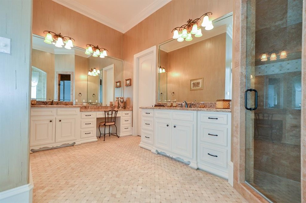 Photo of a large mediterranean master bathroom in Houston with recessed-panel cabinets, white cabinets, a drop-in tub, an alcove shower, pink tile, marble, pink walls, porcelain floors, a drop-in sink, granite benchtops, white floor, a hinged shower door and pink benchtops.