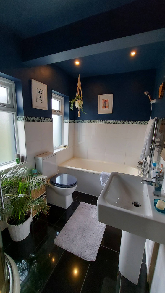 Idéer för att renovera ett mellanstort funkis badrum för barn, med ett platsbyggt badkar, en hörndusch, en toalettstol med hel cisternkåpa, vit kakel, keramikplattor, blå väggar, klinkergolv i keramik, ett piedestal handfat, svart golv och dusch med skjutdörr