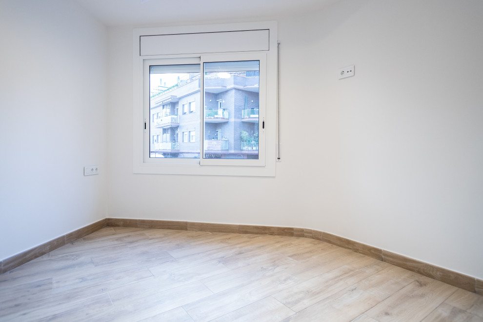 Cette photo montre une chambre parentale tendance de taille moyenne avec un mur blanc, un sol en bois brun, aucune cheminée et un sol marron.