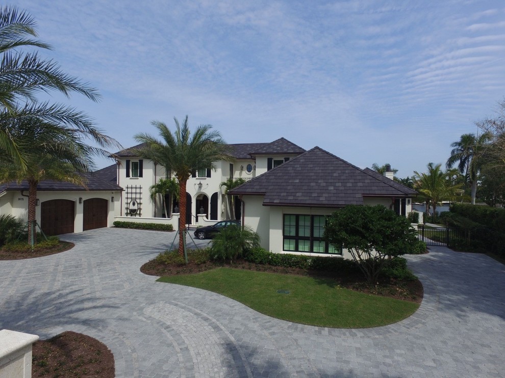 Inspiration for an expansive beach style two-storey stucco white exterior in Miami with a gable roof.
