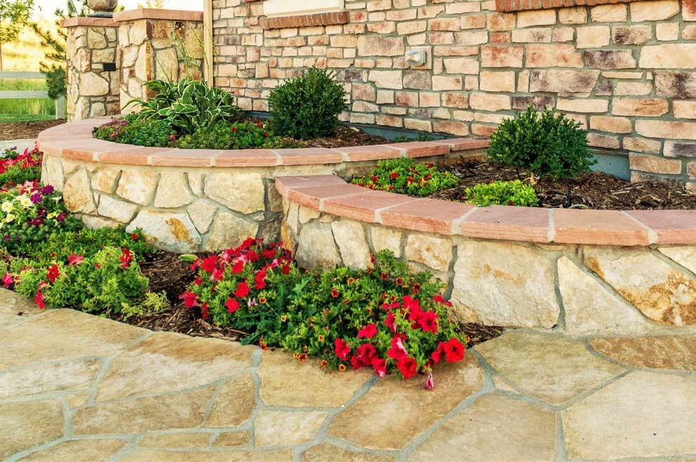 Inspiration for a mid-sized contemporary front yard garden in Denver with a retaining wall and natural stone pavers.
