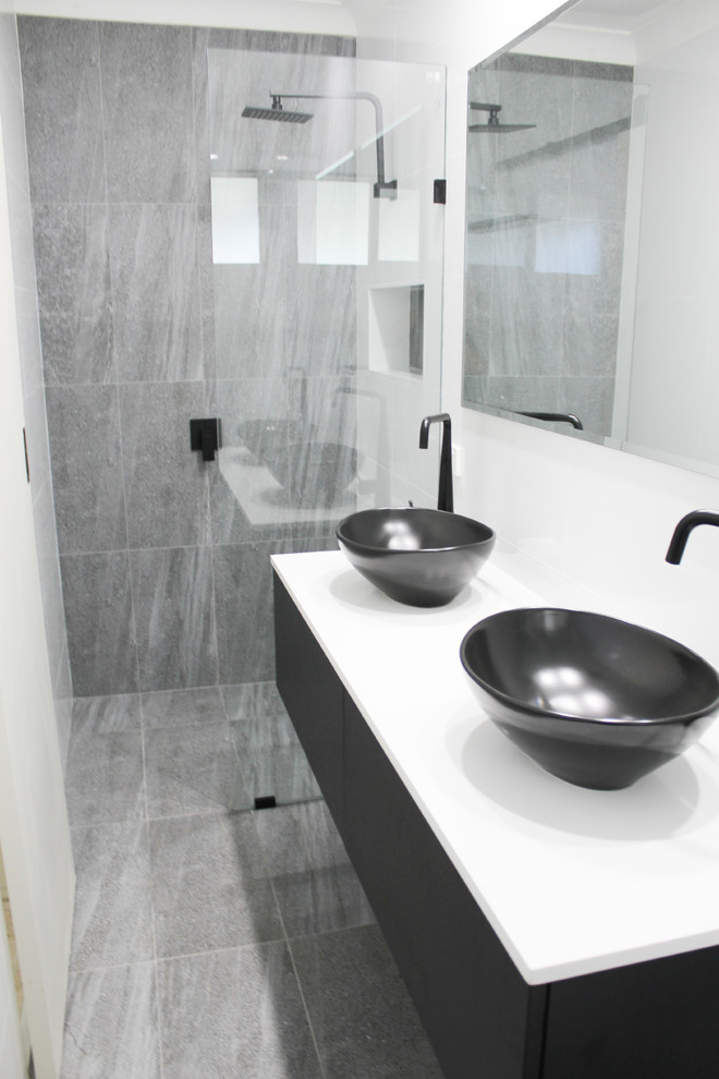 This is an example of a small modern 3/4 bathroom in Perth with flat-panel cabinets, black cabinets, an open shower, a one-piece toilet, white tile, ceramic tile, white walls, porcelain floors, a vessel sink, engineered quartz benchtops, grey floor, an open shower and white benchtops.
