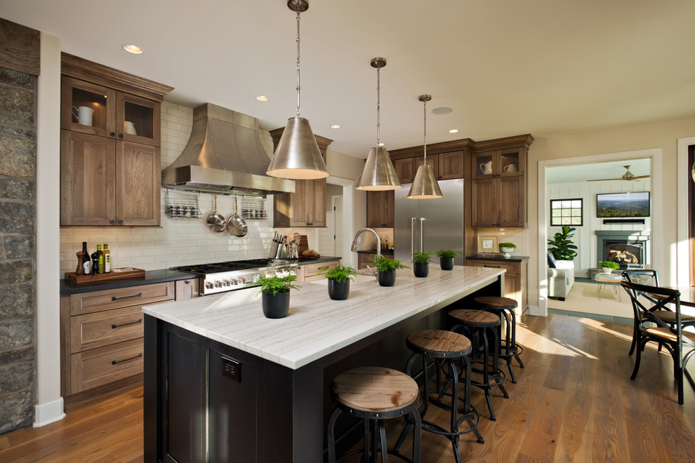 Design ideas for a country eat-in kitchen in New York with soapstone benchtops, white splashback, shaker cabinets, medium wood cabinets, subway tile splashback, stainless steel appliances, medium hardwood floors and with island.