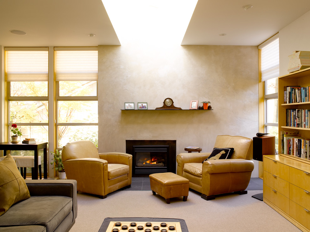 This is an example of a modern living room in Seattle with a library and beige walls.
