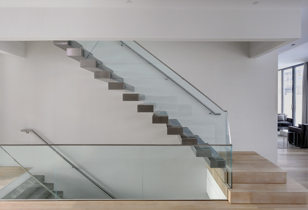 Contemporary floating staircase in New York with glass railing.