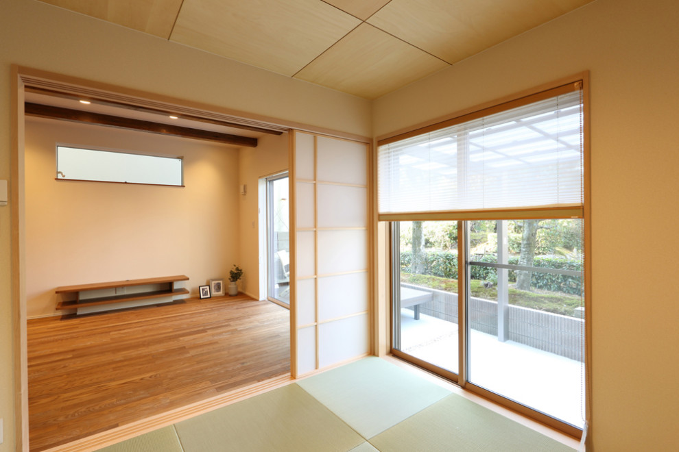 Country family room in Kyoto with beige walls, tatami floors and green floor.