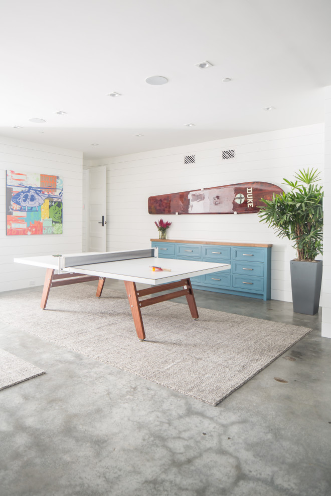 Photo of a large beach style family room in Orange County with white walls, concrete floors and grey floor.
