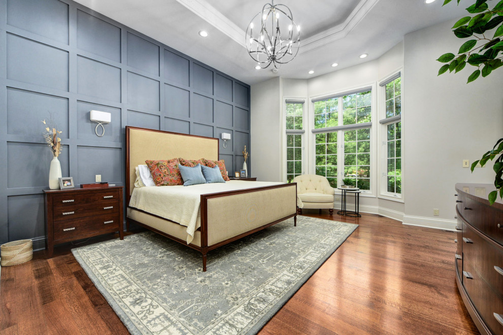 Inspiration for a transitional master bedroom in Cleveland with blue walls, brown floor, recessed and decorative wall panelling.
